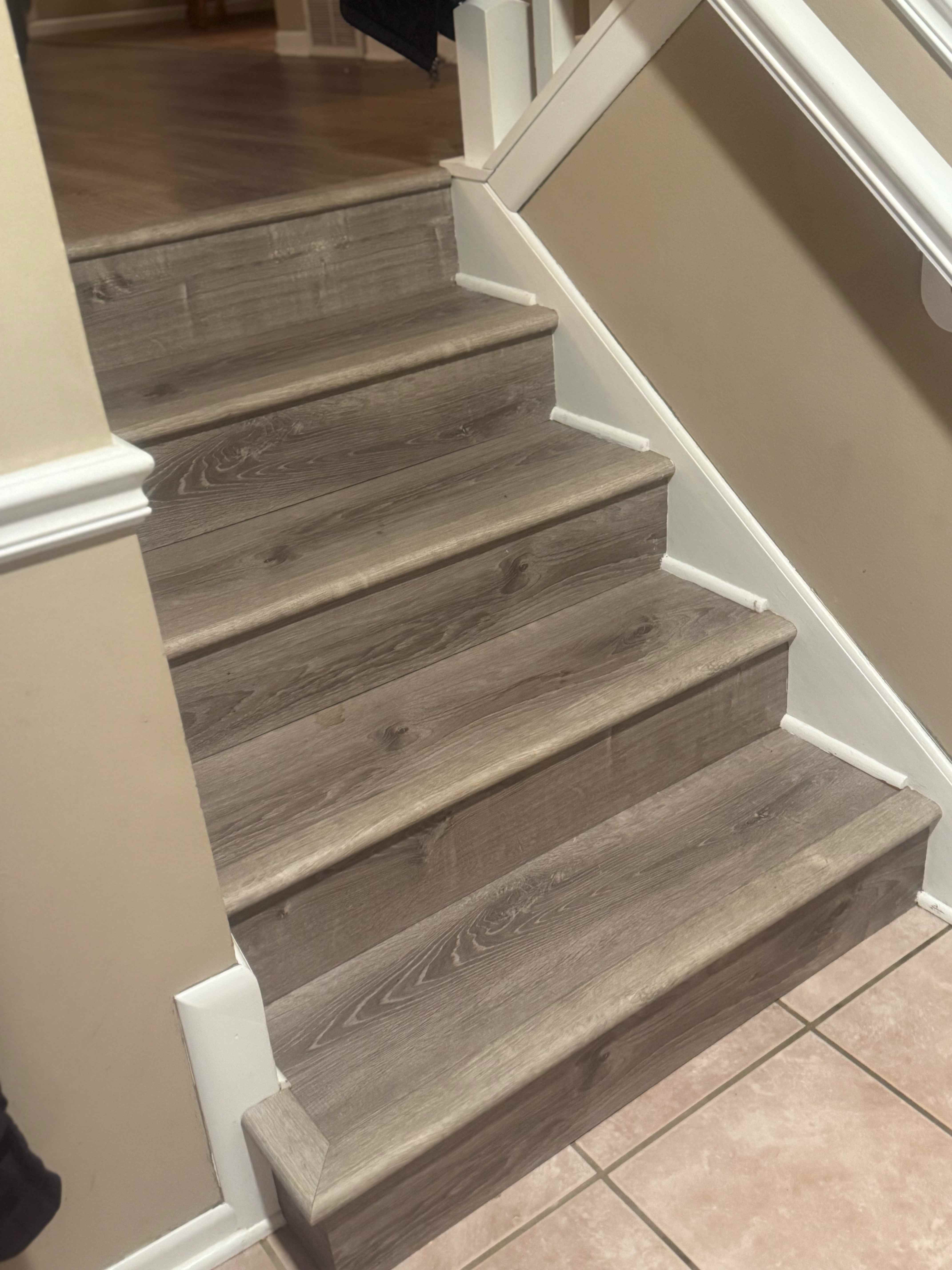 Custom hardwood stair installation with white risers and stained treads